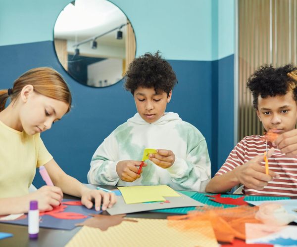 Group of diverse children playfully practicing yoga together in a sunlit studio.