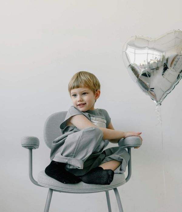 Happy child doing a simple yoga pose in a bright and playful room.